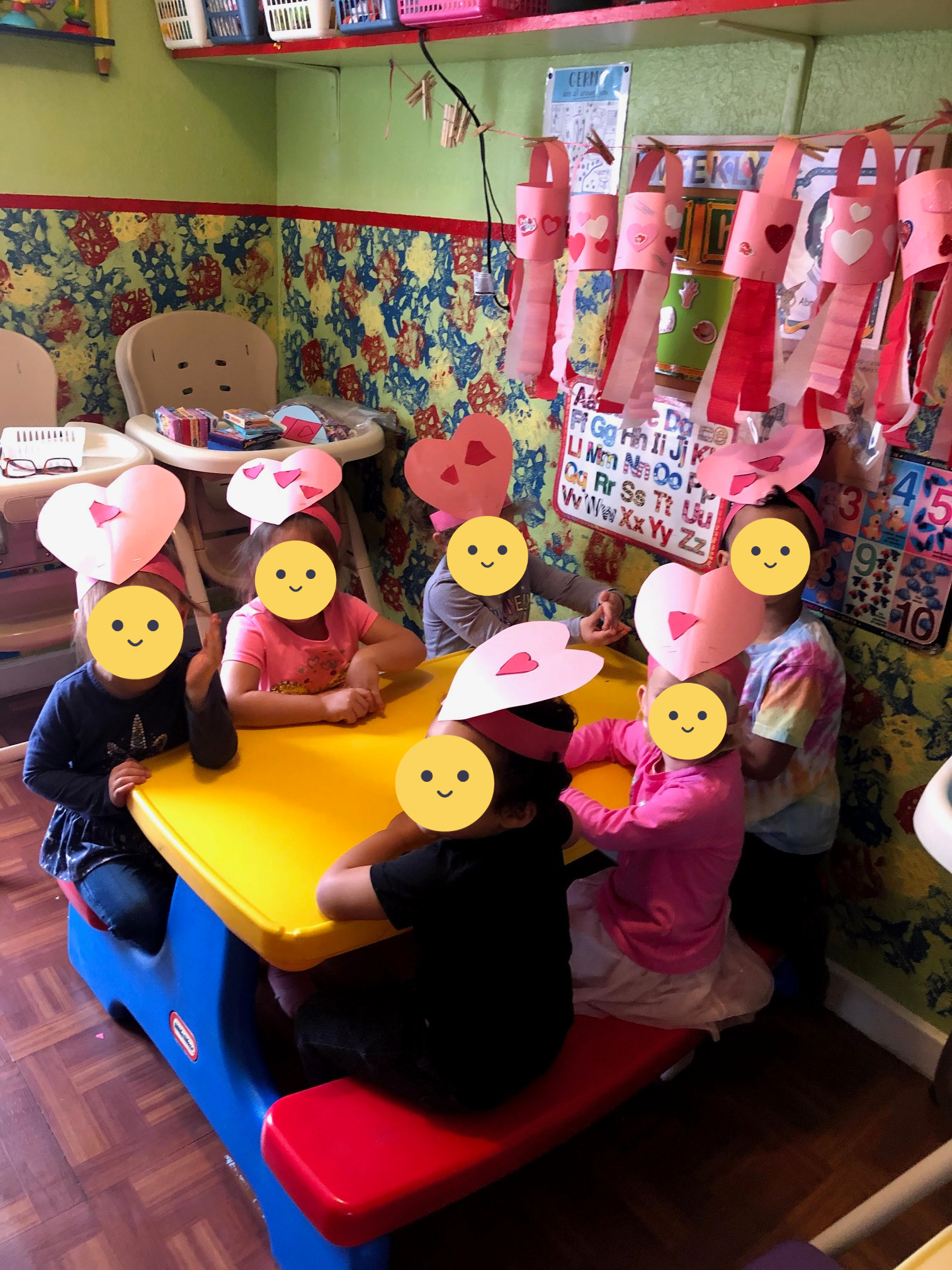 Children sit in the classroom with their constructed heart crowns.